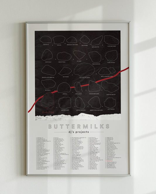 A black color, customized rock climbing ticklist poster for the Buttermilks rock climbing location in Bishop, California. The design has an overlay of crag topography, nature landscapes, and traced boulders, the person's name, and a list of bouldering problems at the bottom. Displayed as wall art in a living room.